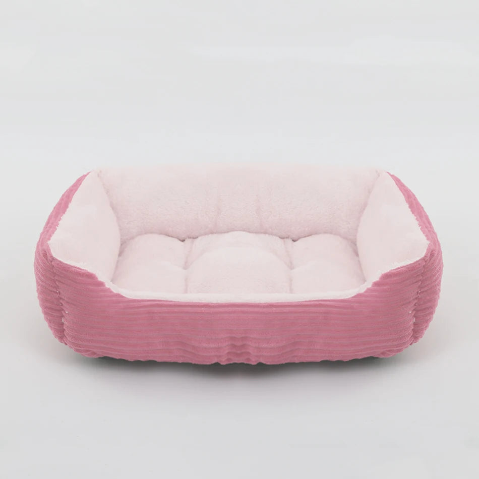 Pink pet bed with white cushion on a light gray background